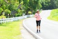 Sporty asian woman runner running and jogging through the road. Royalty Free Stock Photo