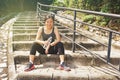 Sporty asian woman sitting outdoors resting drinking water Royalty Free Stock Photo