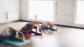 Sporty attractive girls are doing stretching exercises forward bending head to knee position while sitting on colorful Royalty Free Stock Photo