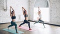 Sporty attractive girls are doing stretching exercises forward bending head to knee position while sitting on colorful Royalty Free Stock Photo