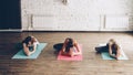 Sporty attractive girls are doing stretching exercises forward bending head to knee position while sitting on colorful Royalty Free Stock Photo