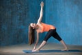 Sporty attractive young woman Doing Parivrrta Trikonasana pose Royalty Free Stock Photo