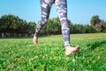 Sporty barefoot woman running on the green grass. Young female legs running barefoot Royalty Free Stock Photo