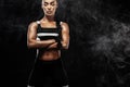 Sporty beautiful afro-american model, woman in sportwear makes fitness exercising at black background to stay fit Royalty Free Stock Photo