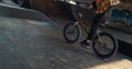 Sporty biker performing tricks on bmx bicycle in urban city skate park.