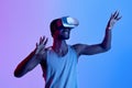 Sporty black athlete wearing VR headset, having virtual training in augmented reality, neon lighting Royalty Free Stock Photo