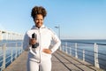 Sporty Black Female With Water Bottle In Hands Standing On Pier Outdoors Royalty Free Stock Photo