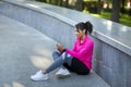 Sporty black woman resting after training at park, using phone Royalty Free Stock Photo