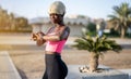 Sporty black woman wearing blond wig tracking her progress on smartwatch outdoors. Royalty Free Stock Photo