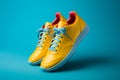 Sporty blue sneakers, laces afloat, set against a lively yellow backdrop