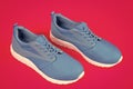 sporty blue sneakers pair on pink background, sport fashion