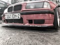 Sporty BMW red car with beautiful big racing wheels with very low ground clearance on cast shiny. Belarus, Minsk, March 8, 2019