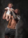 Sporty brutal man holds in arms a little baby