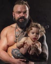 Sporty brutal man holds in arms a little baby