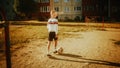 Sporty Caucasian Kid Playing with Ball in the Neighborhood. Young Boy Practicing Soccer Drills