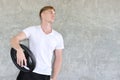 Sporty caucasian man in white sport dress pose lifting a dumbbell and looking away in gym or fitness Royalty Free Stock Photo