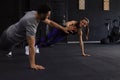 Sporty couple doing push ups and giving high five to each other in gym. Royalty Free Stock Photo