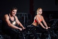 Sporty couple exercising at the fitness the exercise bike on a dark gym. Royalty Free Stock Photo