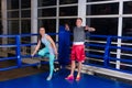 Sporty couple standing near blue corner of a regular boxing ring Royalty Free Stock Photo