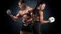 Sporty couple workout with dumbbells. Muscular man and woman showing muscles Royalty Free Stock Photo