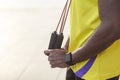 Sporty detail. dark skin man holding jump rope