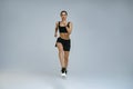 Sporty determined woman wearing sportswear running during cardio workout over studio background Royalty Free Stock Photo