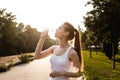 Sporty european girl in white tank top drinks water from bottle Royalty Free Stock Photo