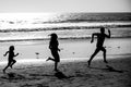 Sporty family father, mother and baby son running together. Child with parents run by water along sea. Sport, health and Royalty Free Stock Photo