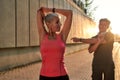 Sporty family. Healthy and active middle-aged couple in sports clothing doing stretching exercises together outdoors Royalty Free Stock Photo