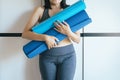 Sporty woman hand holding blue yoga mat after a workout,Exercise equipment Healthy fitness and sport concept Royalty Free Stock Photo