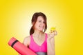 Sporty fit healthy smiling beautiful woman, red head girl holds an apple and yoga mat Royalty Free Stock Photo