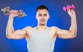 Sporty fit man lifting light and heavy dumbbells. Royalty Free Stock Photo