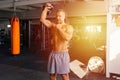 Sporty fit man working out with a kettlebell. Photo of man on dark background.Muscular young man lifting weight in gym