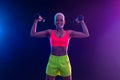 Sporty fit woman, athlete with dumbbells make fitness exercises on neon background. Download cover for music collection