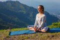 Sporty fit woman practices yoga asana Baddha Konasana outdoors