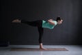 Sporty fit woman practices yoga asana Virabhadrasana 3 Royalty Free Stock Photo