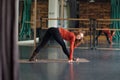 Woman stretching in Parsvottanasana or intense side stretch pose at yoga studio