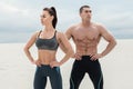 Sporty fitness couple showing muscle outdoors. Beautiful athletic man and woman, muscular torso abs