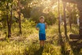 A sporty five-year-old Caucasian boy in a blue t-shirt and shorts stands in the Park in the back sunlight in summer