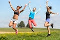 Sporty friends jumping cheerful on sunny meadow Royalty Free Stock Photo