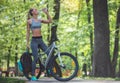 Sporty girl with bike is drinking water Royalty Free Stock Photo