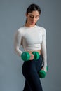 Sporty girl performing arm exercises with dumbbells on grey background Royalty Free Stock Photo