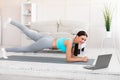 Sporty Girl Exercising At Laptop Standing In Plank At Home Royalty Free Stock Photo