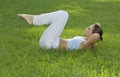 Sporty girl exercising on meadow against the sky Royalty Free Stock Photo