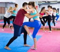 Sporty girl with her instructor are training self-defence moves in gym. Royalty Free Stock Photo