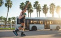 A sporty girl on roller skates against the background of the city in the sunset light on a summer day Royalty Free Stock Photo