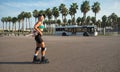 A sporty girl on roller skates against the background of the city in the sunset light on a summer day Royalty Free Stock Photo