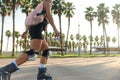 A sporty girl on roller skates against the background of the city in the sunset light on a summer day Royalty Free Stock Photo