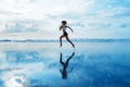 Sporty girl running by beach along sea surf Royalty Free Stock Photo