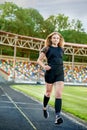 sporty girl running on the stadium track Royalty Free Stock Photo